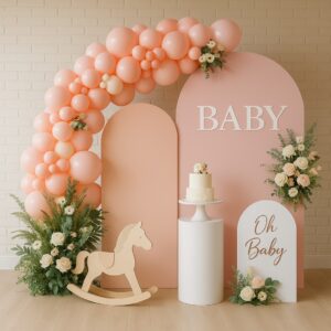 Three wide blush-toned arch panels with full balloon garland, faux florals, rocking horse cutout, cake plinth and themed signage, styled for baby showers and milestone parties.