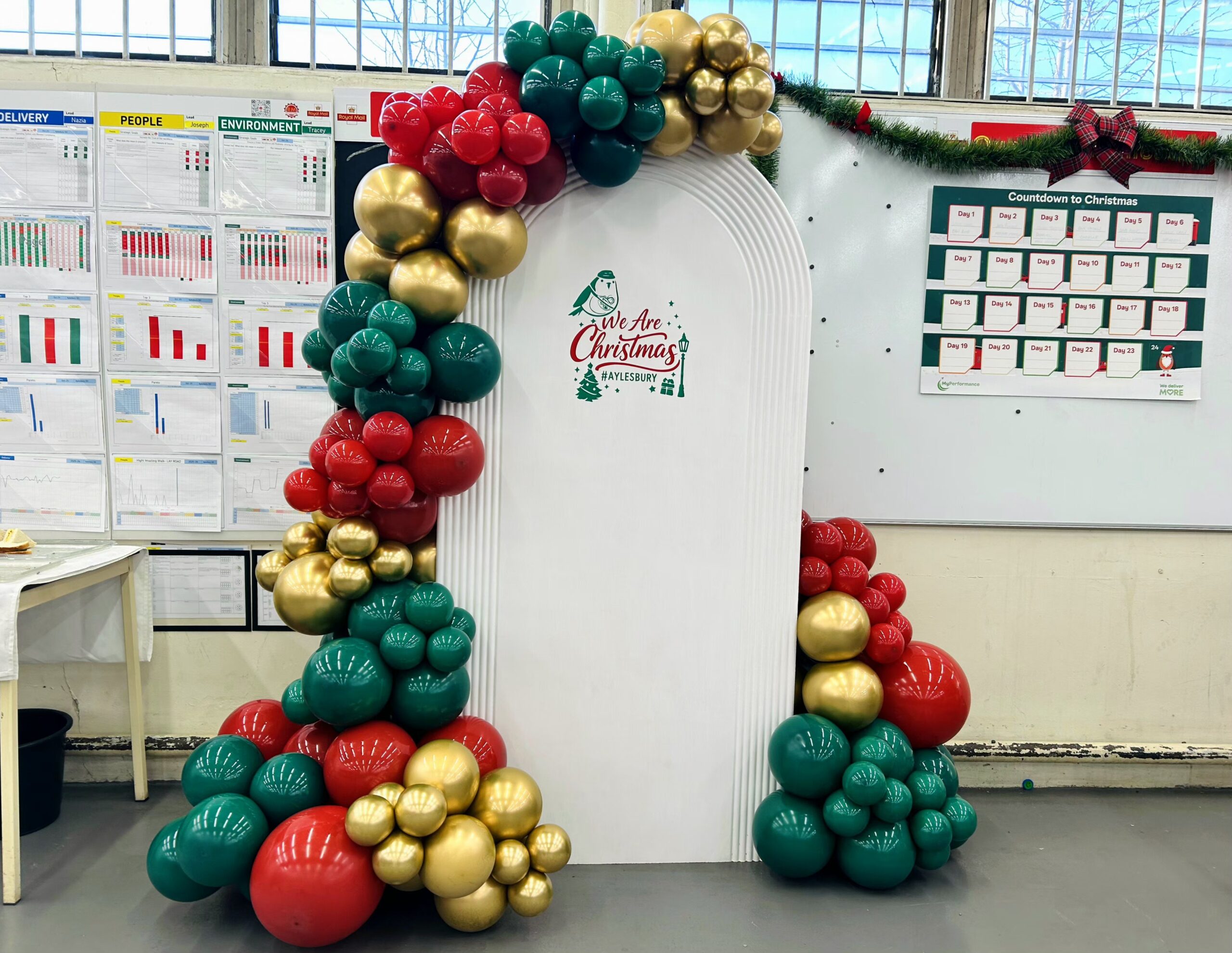 Christmas balloon arch decor in red, green and gold for the Royal Mail Aylesbury office Christmas party